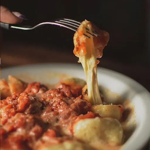 Ñoquis de papa rellenos con muzza y salsa bolognesa.